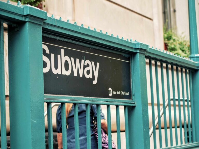 Image shows a green subway entrance barrier.
