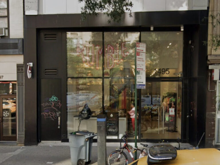 Image shows a two-story storefront with floor to ceiling windows and black trim.