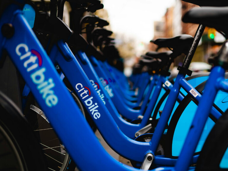 Photo shows a row of blue Citi Bikes in a dock.