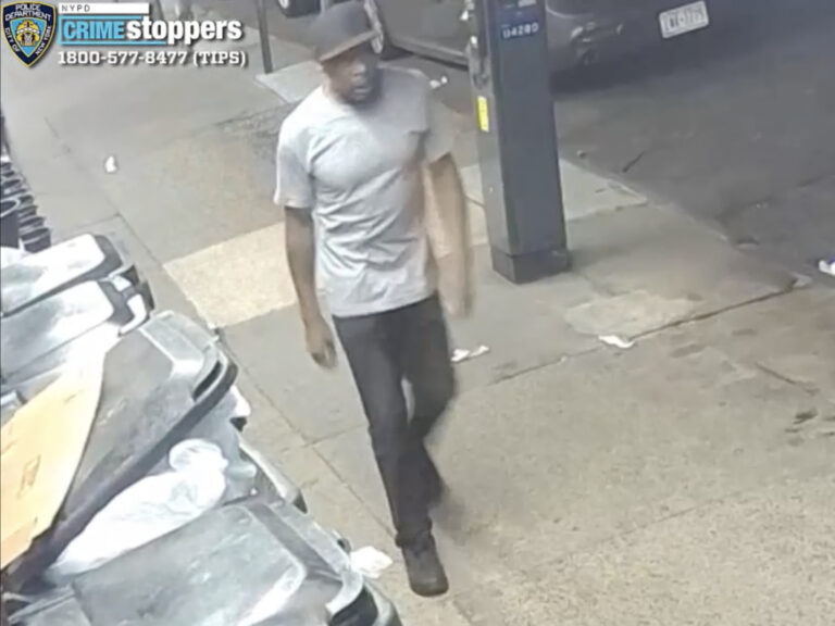 Surveillance image shows man in a grey t-shirt and black hat, pants and shoes.