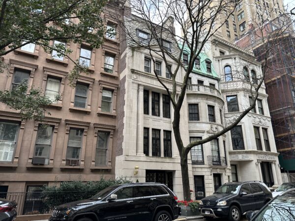 Photo shows a mansion townhouse on an Upper East Side block.