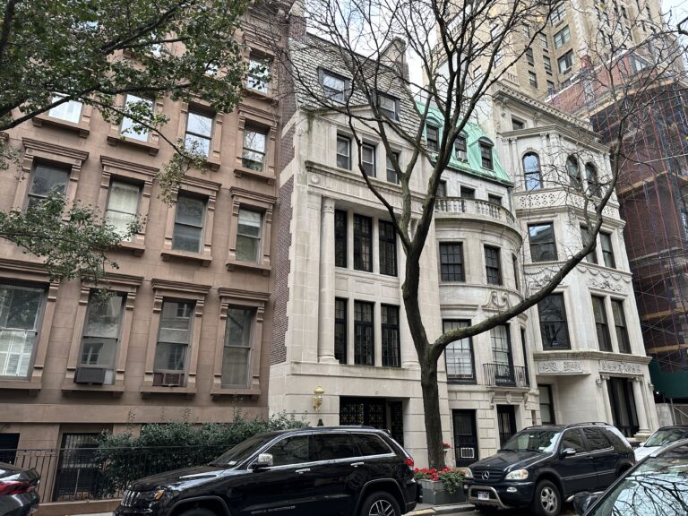 Photo shows a mansion townhouse on an Upper East Side block.