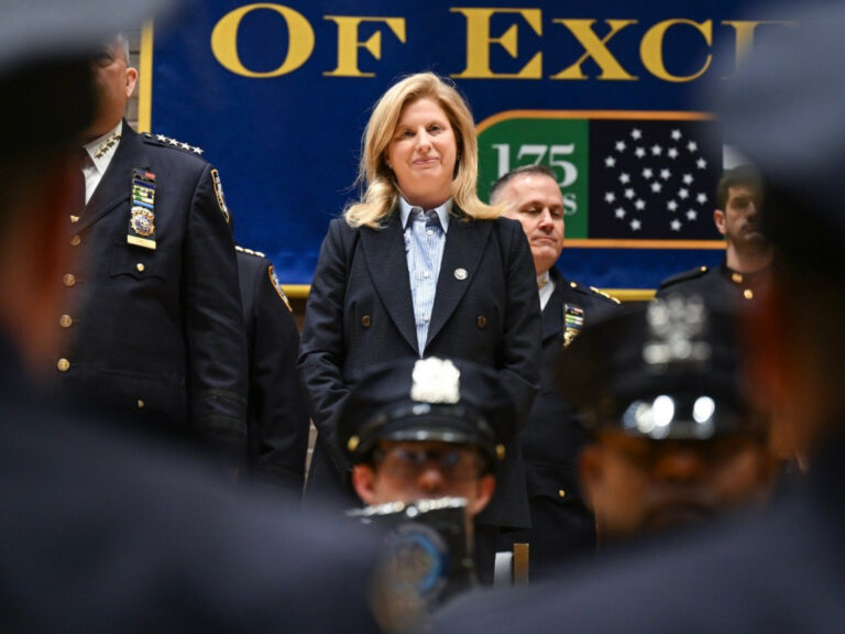 Photo shows police commissioner Jessica Tisch, a blonde woman in a blue suit, standing on stage at a graduation ceremony.